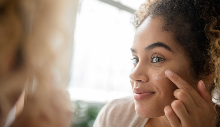 smiling woman examining skin